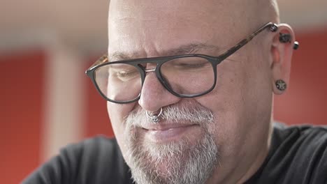 Senior-man-with-piercing,-beard-and-glasses-smiling-portrait