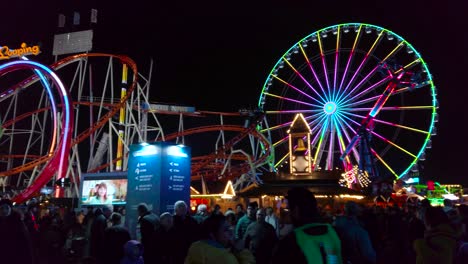 -Pan-low-angle-shot-of-colorfully-lit-up-of-winter-wonderland-in-Hyde-Park-in-London,-England-at-night-time