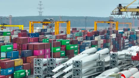 Reihen-Von-Metallcontainern,-Windmühlen-Und-Verschiedenen-Frachtgütern-Stehen-Im-Containerterminal-Und-Warten-Darauf,-Verladen-Und-In-Andere-Teile-Der-Welt-Verschifft-Zu-Werden