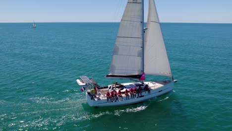 Aerial:-People-on-a-boat-sailing-in-the-beautiful-turqouise-mediterranean-sea-in-Crau-du-Roi,-Montpellier,-France