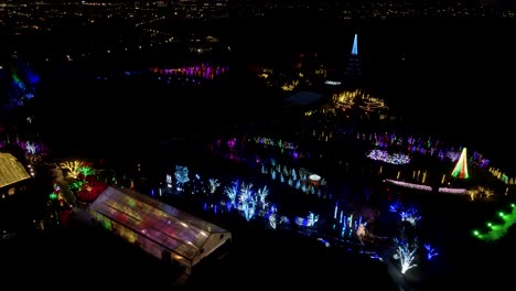 Festival-De-Navidad-En-Un-Parque-Jardín---Vista-Aérea-De-Paralaje-Por-La-Noche