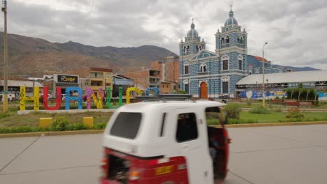 Centro-De-La-Ciudad-De-Huanuco-Con-Rickshaw-Conduciendo-Por-La-Plaza-Principal-Con-La-Catedral-Azul