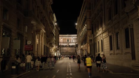 Una-Multitud-De-Personas-Caminando-Y-Trotando-Por-La-Noche-A-Lo-Largo-De-La-Calle-Via-Nazionale-En-El-Centro-De-La-Ciudad-De-Roma,-Italia