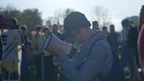 Young-teenage-girl-holding-megaphone-loudspeaker-at-Berlin-protest-gathering