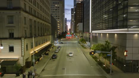 Vista-Aérea-De-Automóviles-Circulando-Por-Calles-Iluminadas-Dentro-De-La-Metrópoli-De-Houston,-Estados-Unidos