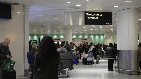 Gente-Dando-La-Bienvenida-A-La-Familia-En-La-Terminal-3-De-Llegadas-Al-Aeropuerto-De-Heathrow,-Volviendo-A-Casa-Por-Navidad