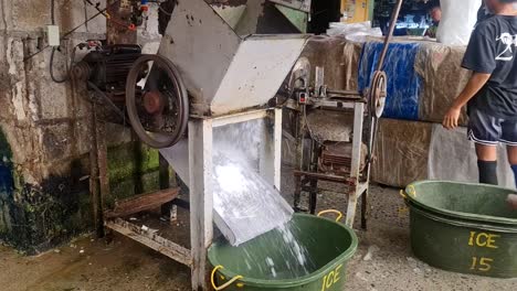 Trabajador-Triturador-De-Hielo-En-Un-Mercado-De-Pescado-En-Filipinas-Cargando-Un-Bloque-De-Hielo-Triturado