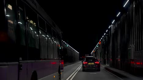 Pov-Dentro-De-La-Conducción-Del-Automóvil-A-Través-De-La-Oscura-Carretera-Del-Túnel-Cerca-Del-Aeropuerto-De-Heathrow-Con-El-Autobús-Que-Pasa-A-La-Izquierda