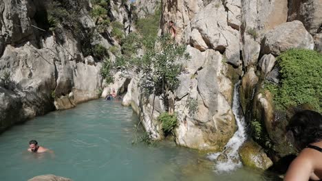 Leute-Schwimmen-Im-Quellwasserbecken-In-Der-Schlucht