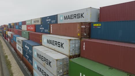 Aerial-view-of-many-empty-metal,-rusted,-and-colored-sea-containers-lined-up-in-a-port-terminal