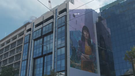 Bright-colourful-moral-woman-with-folded-arms-on-gable-end-of-office-block