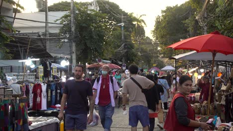 Gente-Caminando-Al-Atardecer-Alrededor-Del-Mercado-De-Pulgas-Al-Aire-Libre-Tailandés