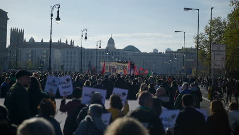 Huge-crowd-gathering-in-Berlin-economic-inflation-protest-with-banners-and-flags,-Slow-motion