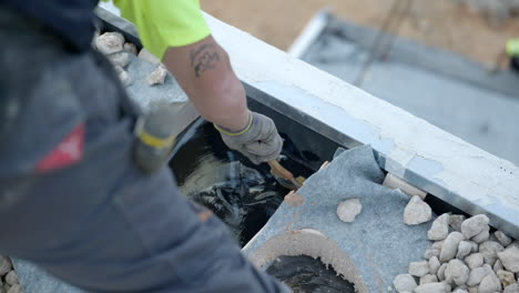 Trabajador-De-La-Construcción-Que-Aplica-Un-Recubrimiento-Líquido-De-Betún-Negro-Al-Techo-De-La-Casa-De-Cerca