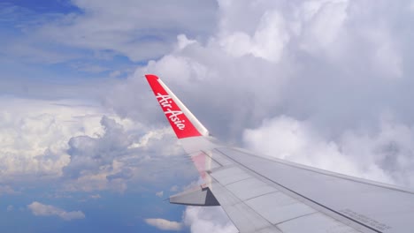 Innenansicht-Des-Air-Asia-Flügels,-Der-Durch-Bewölkten-Himmel-Fliegt