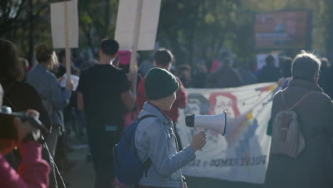 Passionate-young-female-activist-holding-megaphone-at-economic-inflation-crisis-protest-in-Berlin,-Slow-motion