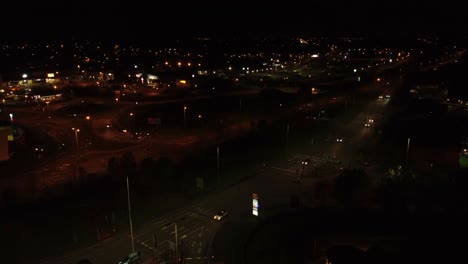 Noche-Volando-Sobre-La-Autopista-De-La-Ciudad-Del-Reino-Unido-Con-Luces-De-Calle-Iluminadas-Y-Vista-Aérea-Del-Logotipo-Publicitario-De-Mcdonalds