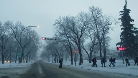 group-of-people-crossing-the-street-in-small-town-as-the-pedestrian-lights-blink