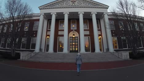 Mujer-Caminando-Hacia-La-Entrada-De-La-Biblioteca-Baker-Y-El-Centro-Bloomberg-En-La-Escuela-De-Negocios-De-La-Universidad-De-Harvard-En-Boston,-Massachusetts