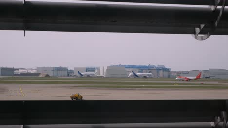 View-of-Airbus-factory-in-Toulouse-with-a-moving-Beluga-cargo-aircraft,-an-Easyjet-Airbus-319-departing-and-a-marshaller