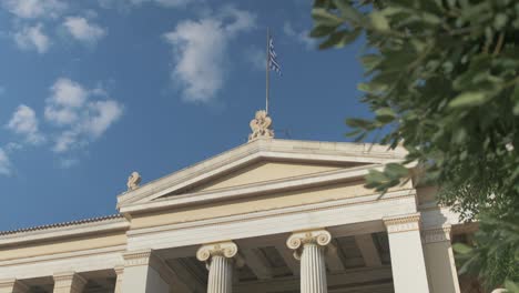 Nationaler-Kapodistrianischer-Universitätsgiebel-Mit-Griechischer-Flagge,-Die-Im-Wind-Weht