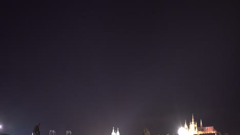 Crowd-walking-on-Charles-bridge-in-Prague-at-night,-birds-flying-above