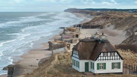 Casa-Danesa-En-La-Playa-Con-Búnkeres-En-El-Fondo-Disparados-Por-Drones