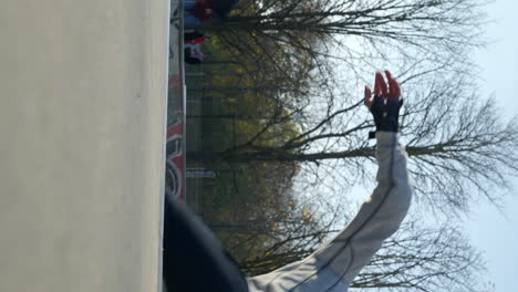 VERTICAL-active-skateboarder-rides-skate-bowl-in-slow-motion-in-urban-skatepark