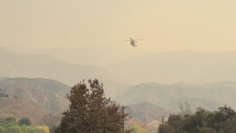 Large-Helicopter-taking-water-from-lake-to-put-out-large-fire-at-Fairview-Fire,-Hemet,-California,-USA