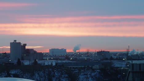 Ein-Blauer,-Rosa-Und-Orangefarbener-Sonnenaufgang-Im-Zeitraffer-Mit-Einer-Stadt-Im-Vordergrund