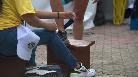 Slow-motion-close-up-of-a-marshall-taking-off-the-tag-on-a-competitors-ankle-at-a-triathlon