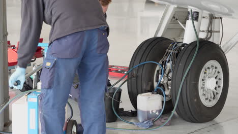 Technicians-working-on-hydraulic-system-of-airplane's-landing-gear