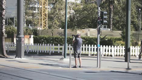 Turista-Masculino-Con-Una-Cámara-Tomando-Fotos-Y-Videos-En-La-Calle