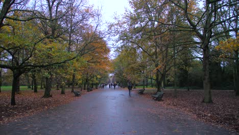 People-Walking-On-The-Wet-Pavement-In-The-Regent's-Park-On-A-Cloudy-Day-In-Camden,-London,-UK