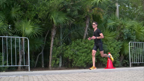 Cámara-Lenta-De-Un-Atleta-Masculino-Que-Usa-Un-Traje-Negro-Compitiendo-En-La-Etapa-De-Carrera-De-Un-Triatlón