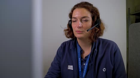 Woman-working-in-a-call-center-responding-to-calls-with-her-head-phone