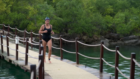 Cámara-Lenta-De-Una-Atleta-Corriendo-Cruzando-Un-Puente-En-Una-Transición-En-Una-Competencia-De-Triatlón