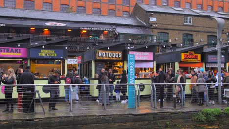 Shot-of-locals-and-tourists-enjoying-snacks-along-the-outside-of-Camden-Market-in-London,-United-Kingdom-at-daytime