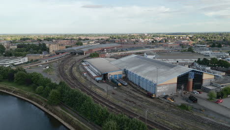 Aerial-Drone-Shot-of-National-Railway-Museum-with-River-Ouse-and-York-Railway-Station-in-Background-on-Sunny-and-Cloudy-Evening-North-Yorkshire-UK