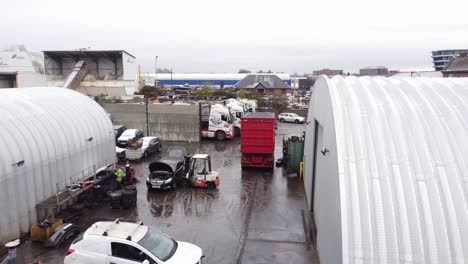 Aerial-view-descending-to-backstreet-city-industrial-truck-logistics-yard