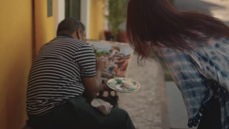 Artista-Callejero-Pintando-Mientras-Las-Mujeres-Están-Mirando