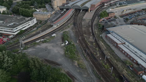 Un-Dron-Aéreo-Disparó-Sobre-La-Estación-De-Tren-De-York-Con-Un-Tren-Que-Pasaba-A-Través-De-Un-Disparo-En-Una-Noche-Soleada-Y-Nublada-North-Yorkshire,-Reino-Unido