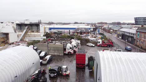 Vista-Aérea-Elevándose-Sobre-Backstreet-City-Industrial-Truck-Yard-Lugar-De-Trabajo-Mecánico