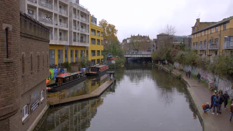 Disparo-En-ángulo-Alto-Sobre-Regent&#39;s-Canal-En-El-área-De-Camden-En-Londres,-Reino-Unido,-Con-Lugareños-Pasando-Junto-Al-Canal-En-Un-Día-Nublado