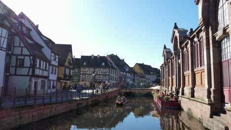 Turistas-Navegando-A-Lo-Largo-Del-Canal-En-El-Casco-Antiguo-De-La-Pequeña-Venecia-En-Colmar,-Francia