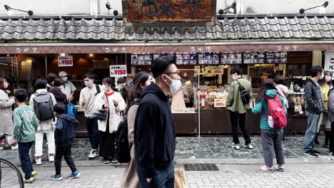 Personas-Con-Mascarillas-En-La-Concurrida-Calle-Del-Mercado-De-Alimentos-En-Nara,-Japón