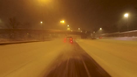 POV-shot-traveling-along-a-highway-with-a-car-kicking-up-snow-powder-in-Helsinki