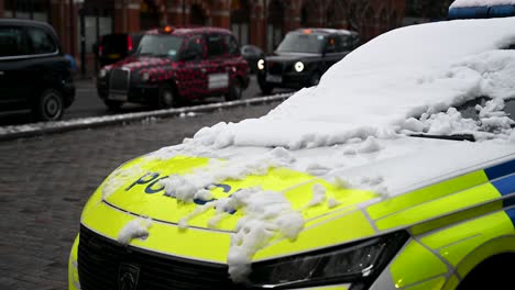 Varios-Taxis-Pasan-Por-La-Policía-Junto-A-St-Pancras-En-Londres,-Reino-Unido.