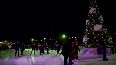 Gente-Patinando-Alrededor-Del-árbol-De-Navidad-En-La-Pista-De-Hielo-De-Glide-Battersea-Por-La-Noche