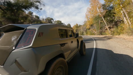 Fpv-drone-shot-of-black-suv-car-driving-fast-on-road